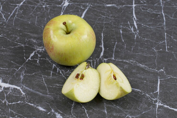 Whole and sliced apples on marble. Free Photo