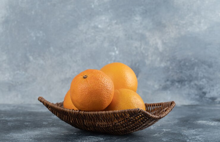 A wicker basket full of orange fruits. Free Photo