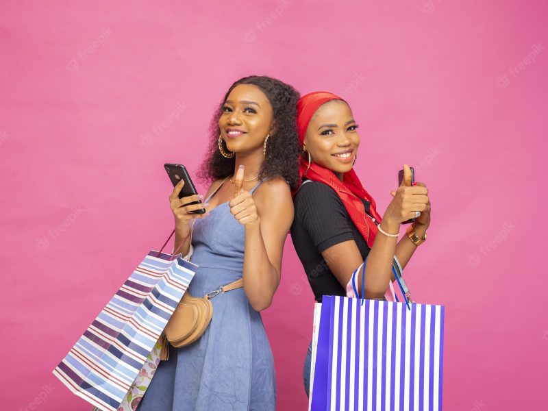 Happy young African black ladies posing with shopping bags with thumbs up Free Photo Happy young African black ladies posing with shopping bags with thumbs up Free Photo
