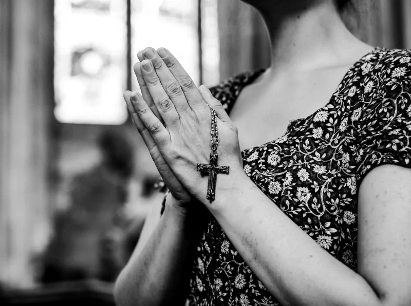 Catholic woman praying with a rosary at the church Free Photo