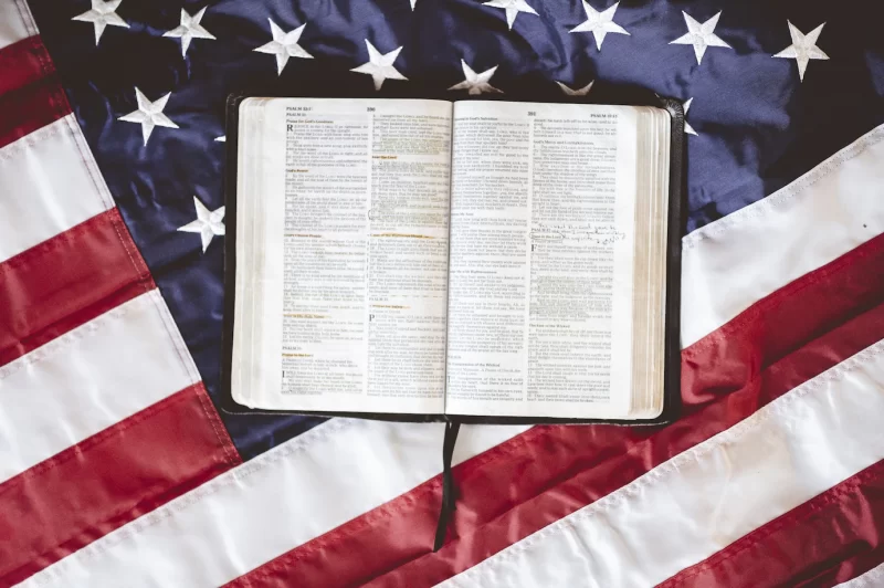 Closeup shot of the bible open in pages put on the american flag – perfect for praying concept Free Ph