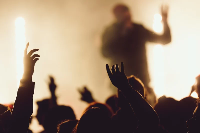 Dancing at a concert while the singer is performing surrounded with lights Free Photo