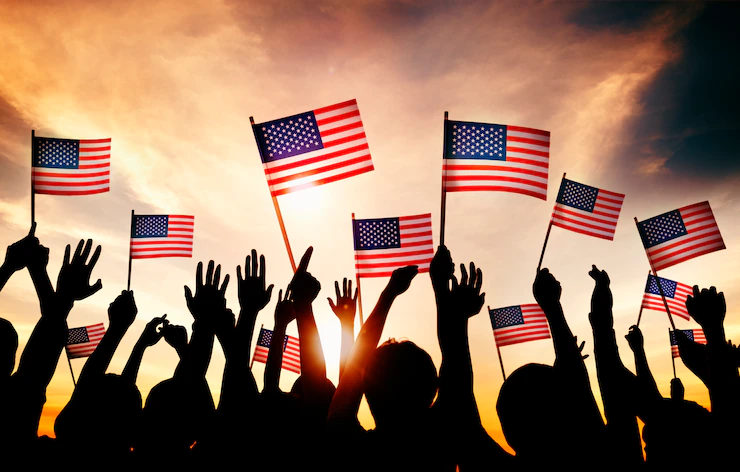 Group of people waving american flags in back lit Free Photo