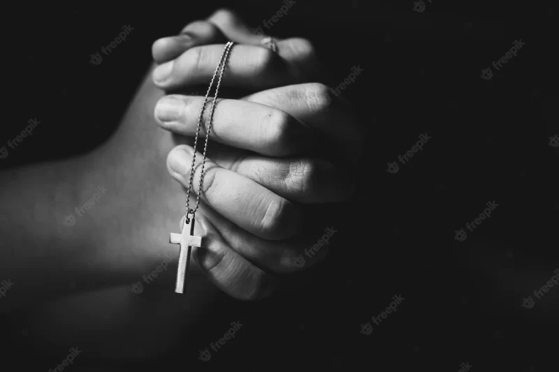 Hands holding cross while praying. Free Photo