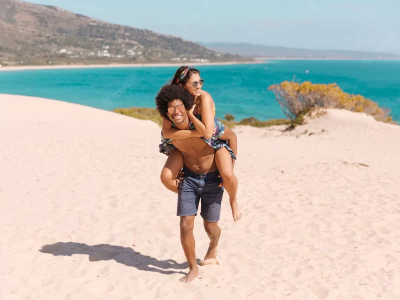 African American couple on the beach having fun – free photo