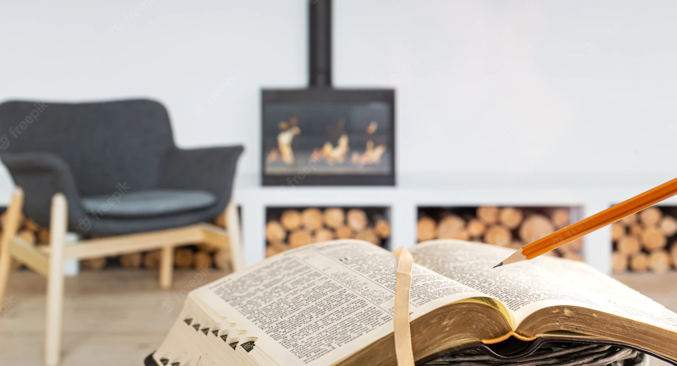 Man Holding Bible With Pencil Against Background Living Room With Fireplace Reading Book Cozy Environment 169016 3162