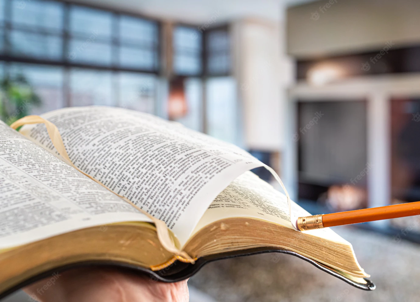 Man Holds Bible With Pencil Against Background Living Room Reading Book Cozy Atmosphere Close Up 169016 15652