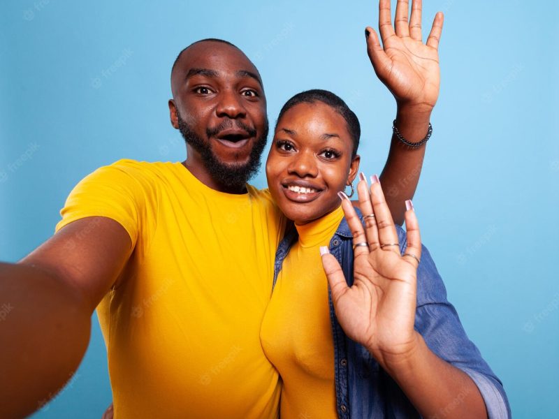 Selfie of cute black lovers waving at camera and taking pictures Selfie of cute black lovers waving at camera and taking pictures