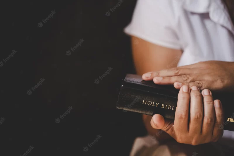 Spirituality and religion, hands folded in prayer on a holy bible in church concept for faith. Free Phot