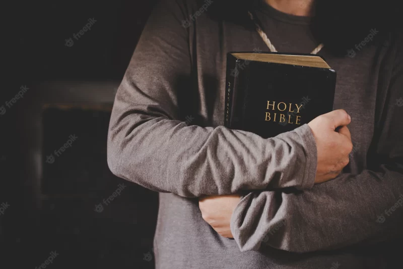 Spirituality and religion, hands folded in prayer on a holy bible in church concept for faith. Free Phot