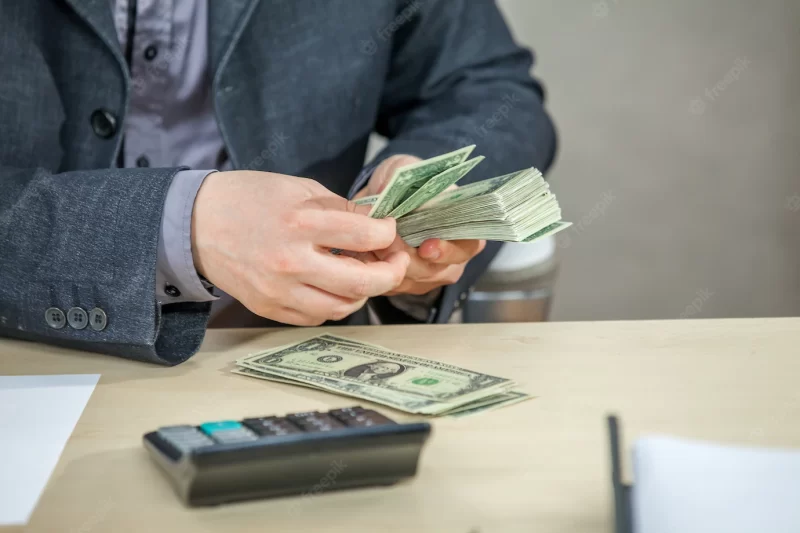 Young businessman working from his office and counting cash money Free Photo