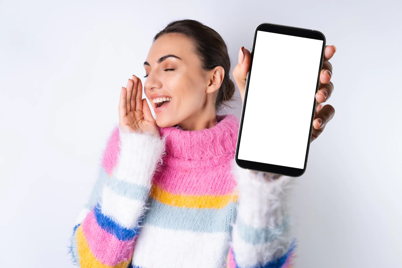 Young Cheerful Girl Bright Colored Sweater White Background Holds Big Phone Focus With Blank White Screen 343596 8032