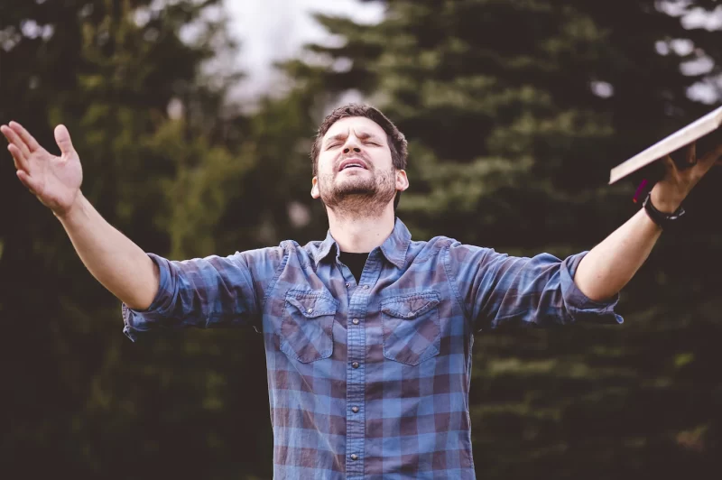 Young male speaking and holding the bible in his hands Free Photo