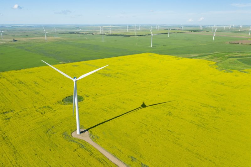 Aerial shot of wind generator in a large field during daytime Free Photo