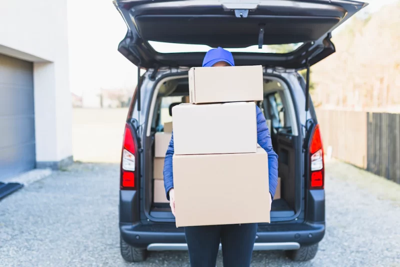 Anonymous courier with plenty of boxes Free Photo