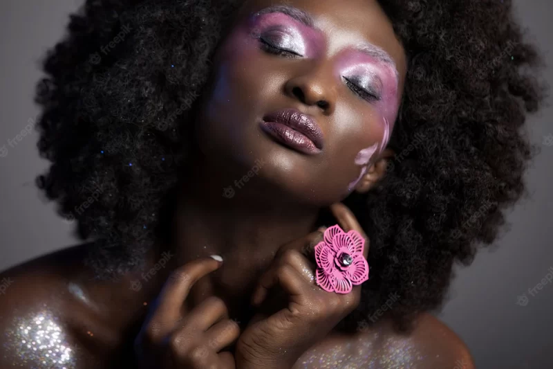 Beautiful african woman with big curly afro and flowers in her hair Free Photo