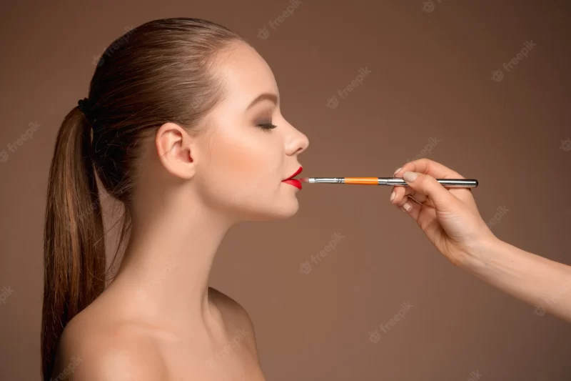 Beautiful female lips with make-up and brush Free Photo