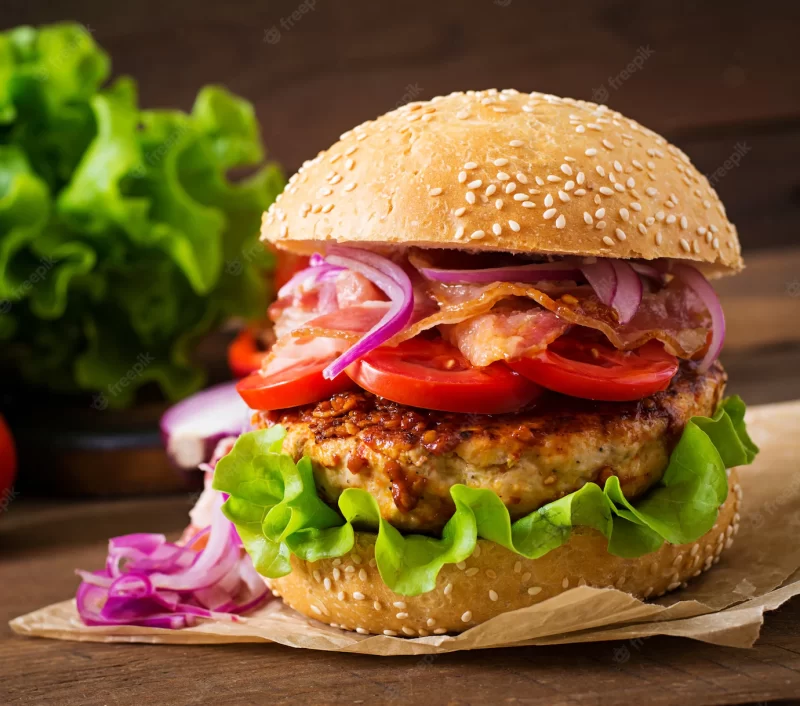 Big sandwich – hamburger burger with beef, red onion, tomato and fried bacon. Free Photo