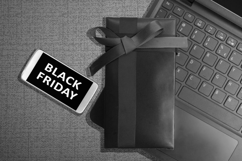 Black friday message on the mobile phone screen with gift box on black background. black Friday concept Free Photo