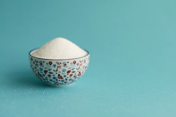 Bowl of sugar on a light blue surface Free Photo