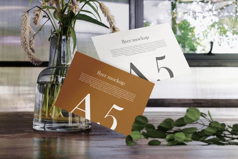 Clean minimal a5 flyer mockup floating on wooden table with vase and plant psd file Free Psd