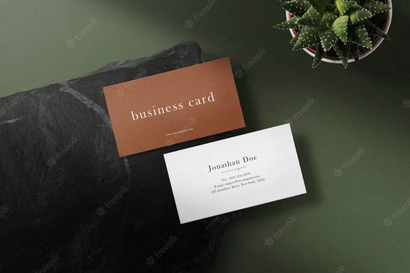 Clean minimal business card mockup on black stone with leaf Free Psd