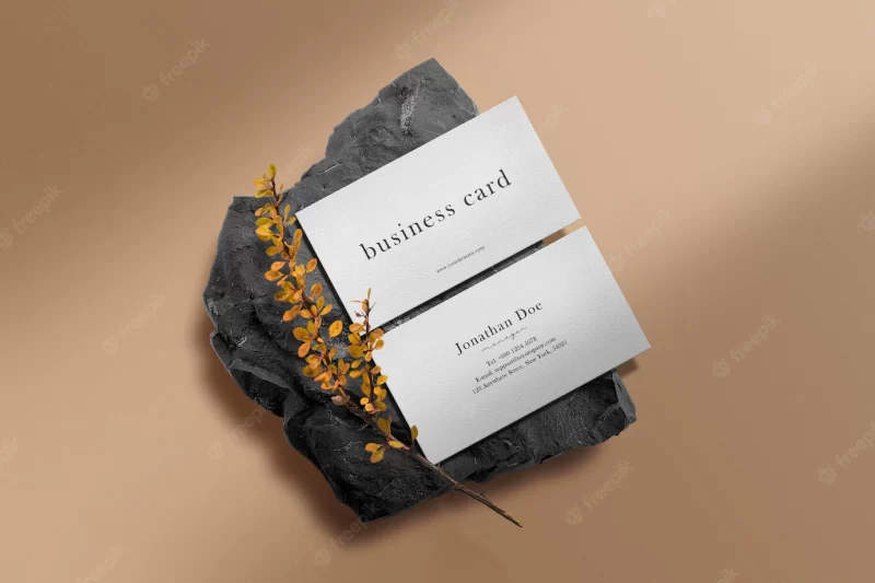 Clean minimal business card mockup on black stone with yellow plant Free Psd