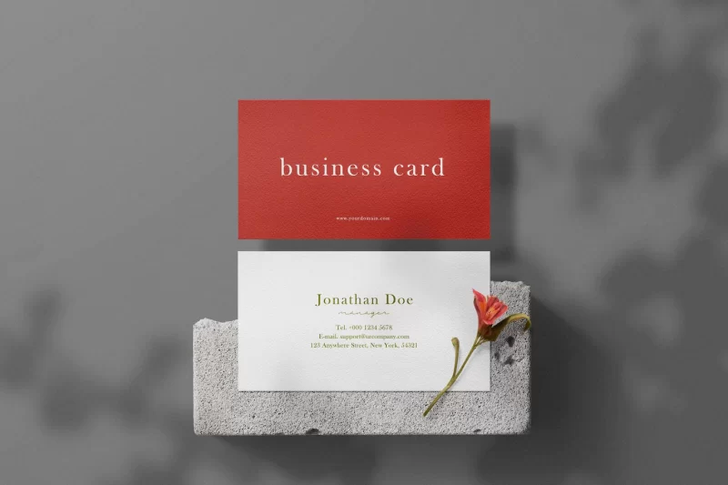 Clean minimal business card mockup on concrete with flower Free Psd