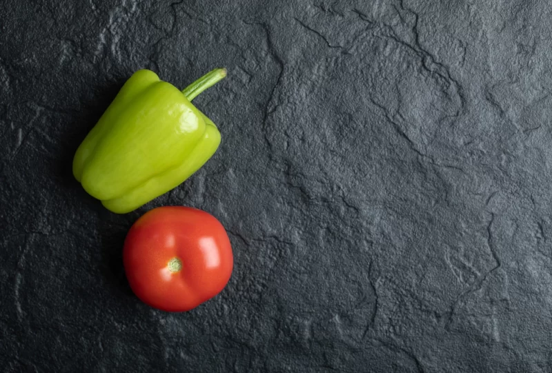 Close up photo of tomato and pepper on black background Free Photo