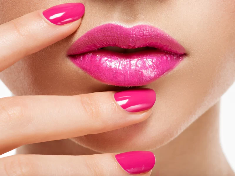 Closeup woman hand with pink nails near lips. fingernails with pink manicure Free Photo