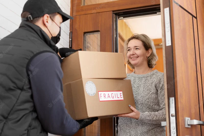 Courier delivering parcel to client Free Photo