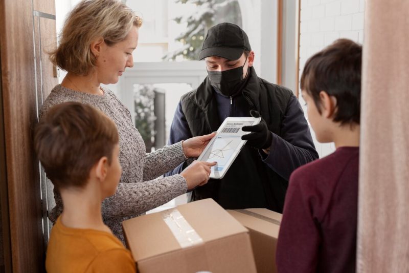 Courier delivering parcel to client Free Photo