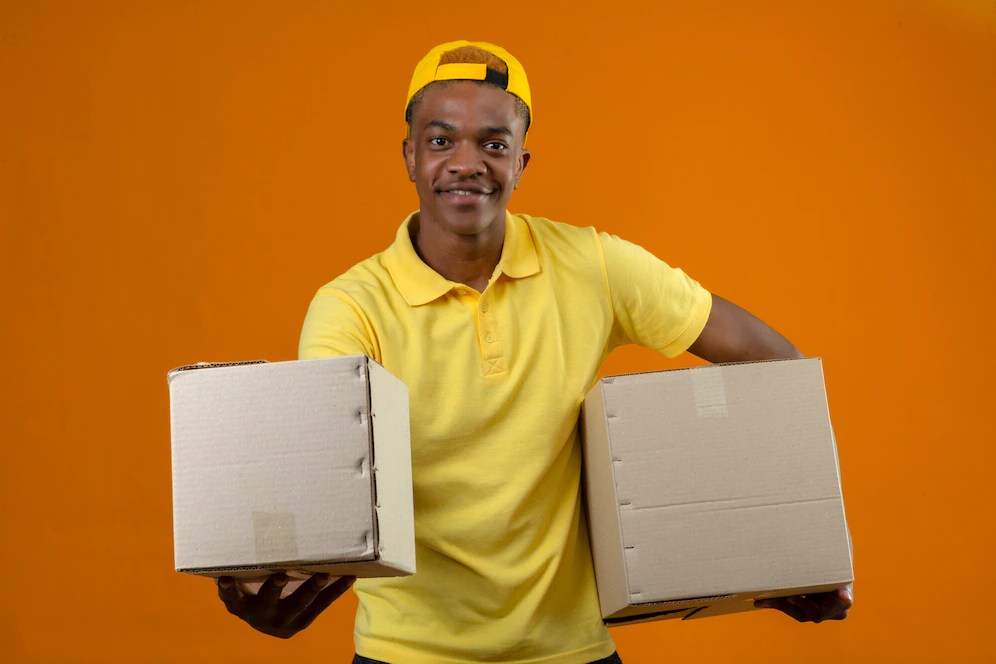 Delivery African American Man Yellow Polo Shirt Cap Standing With Cardboard Boxes Hands Smiling Friendly Isolated Orange 141793 18891