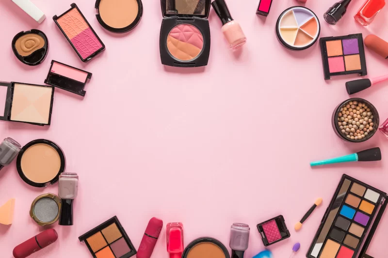 Different cosmetics types scattered on pink table Free Photo