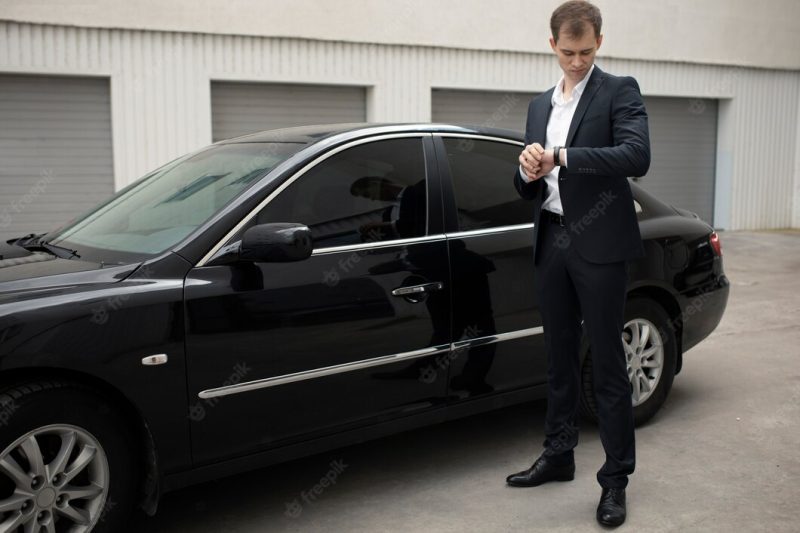 Elegant man standing next to his car for taxi services Free Photo