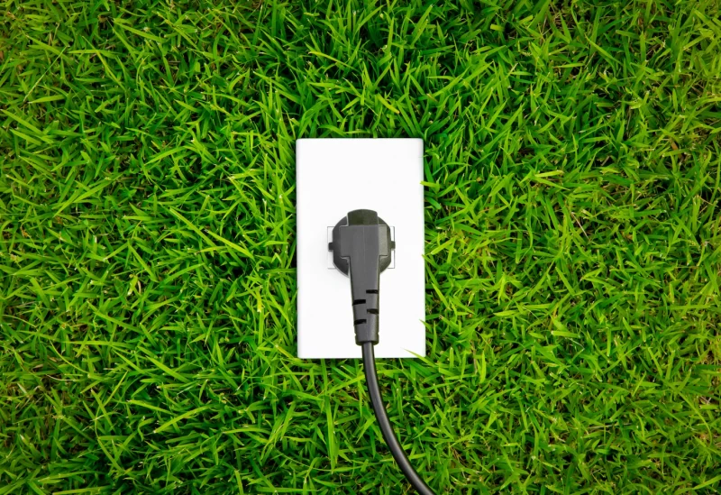 Energy concept outlet in fresh spring green grass Free Photo