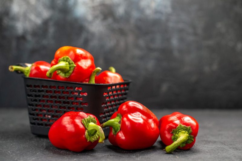 Front view red bell-peppers spicy vegetables on a dark background Free Photo