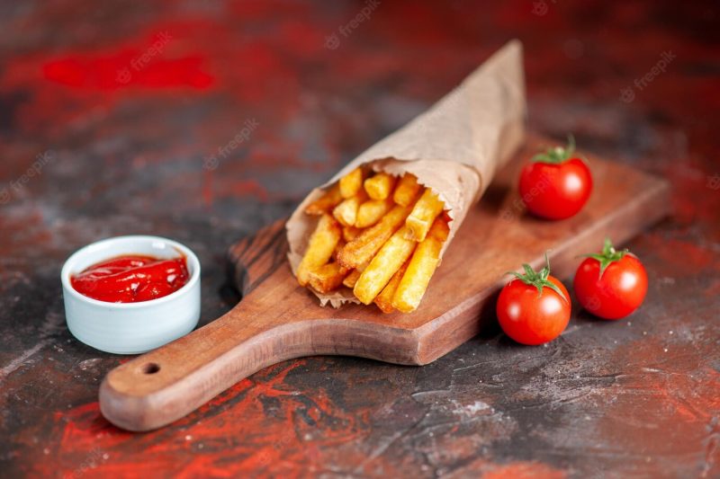 Front view yummy french fries with red tomatoes and ketchup on dark background dish fast-food sandwich toast snack dinner Free Photo