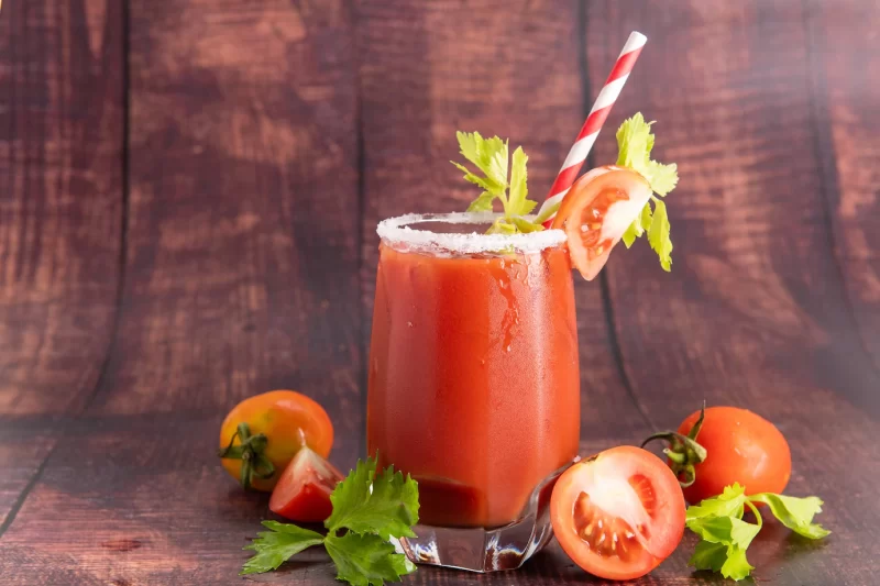 Glass glass of tomato juice with fresh bright tomatoes, green parsley on a dark background. vegetable drink. Free Photo