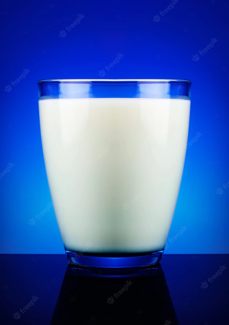 Glass of milk and blue surface Premium Photo