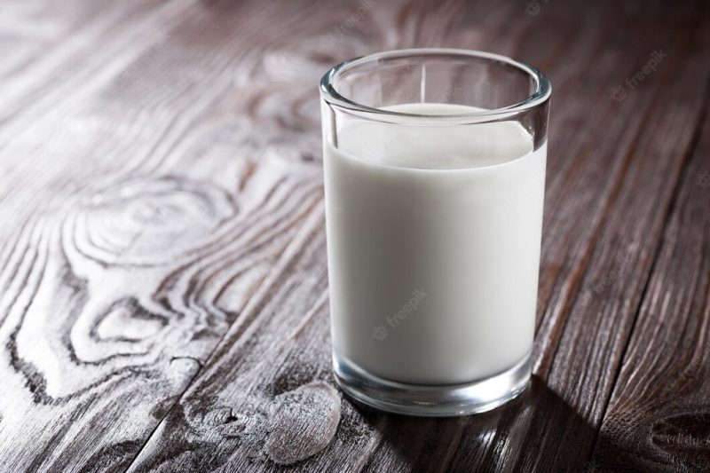 Glass of milk on wooden table Premium Photo