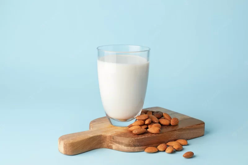 Glass of tasty almond milk on color background Premium Photo