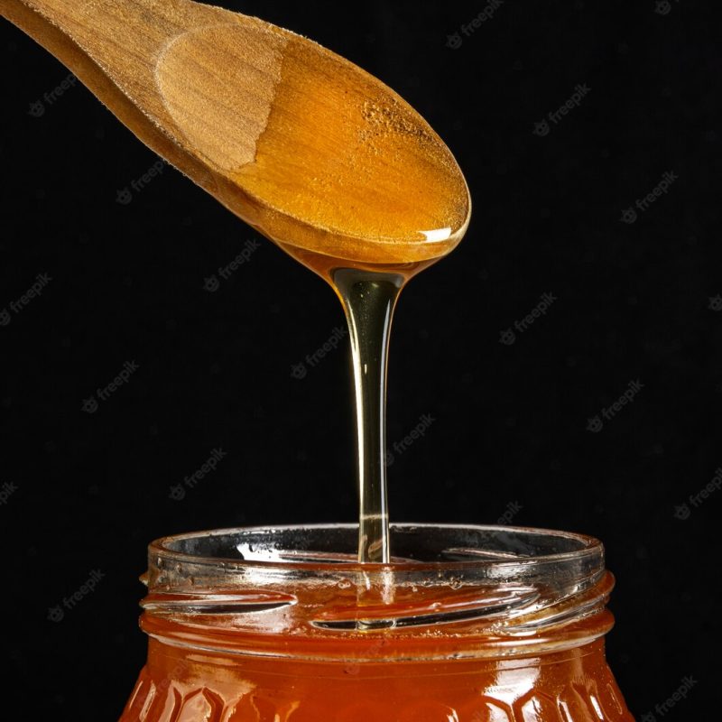 Honey jar with wooden spoon Free Photo