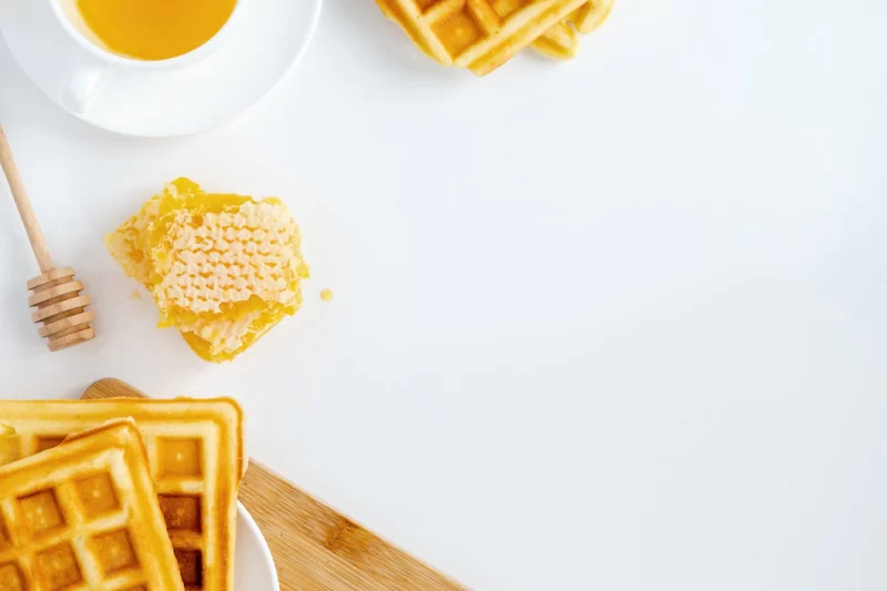 Honey products composition. honeycomb, waffles, tea and special spoon. white background Fr