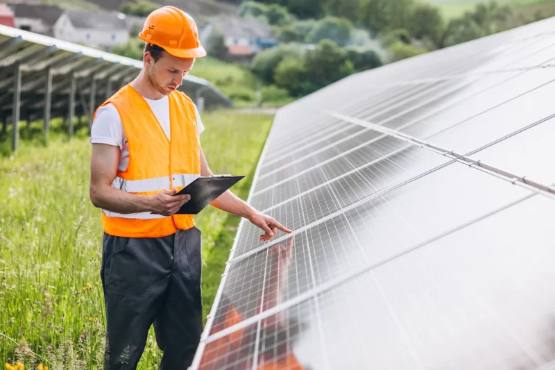 Man worker in the field by the solar panels Free Photo