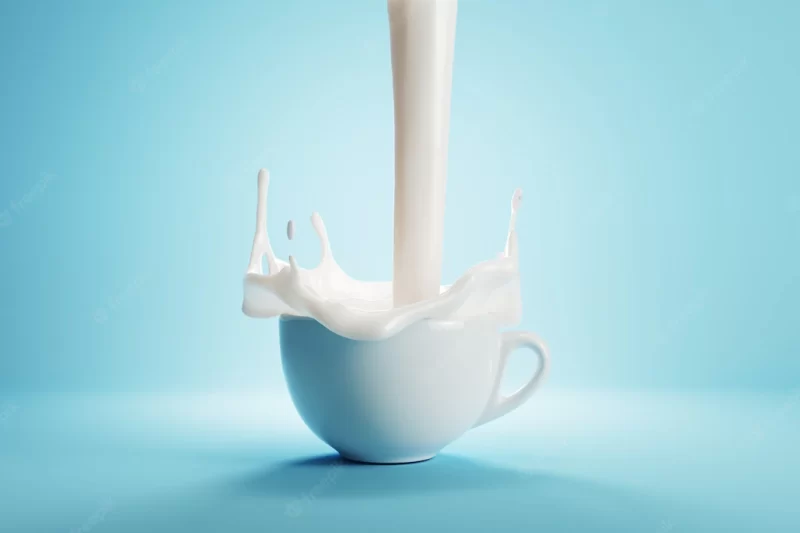 Milk pouring on a white cup of coffee on blue background color. 3d render Premium Photo