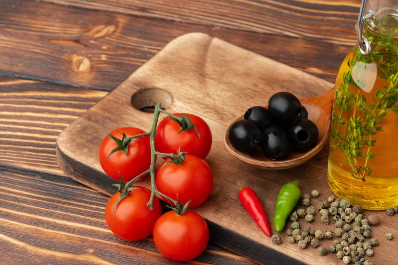 Olive oil olives and tomatoes on wooden background Free Photo