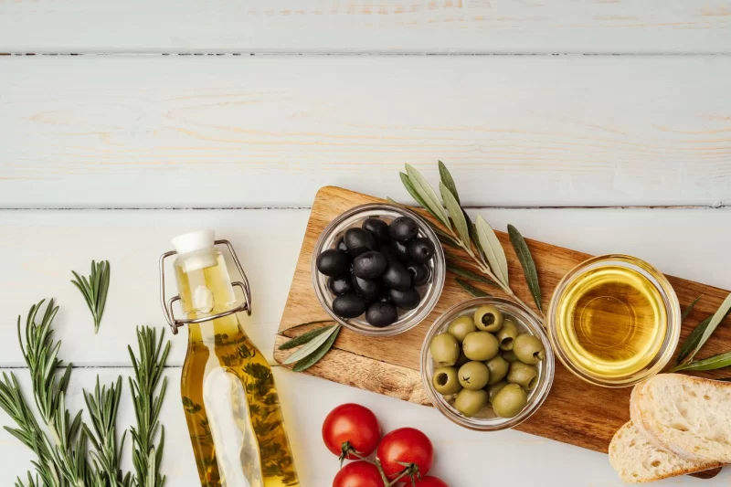 Olive oil olives and tomatoes on wooden background Free Photo