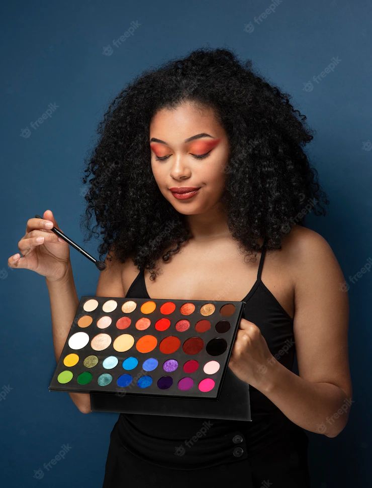 Portrait of a gorgeous woman holding an eyeshadow palette Free Photo