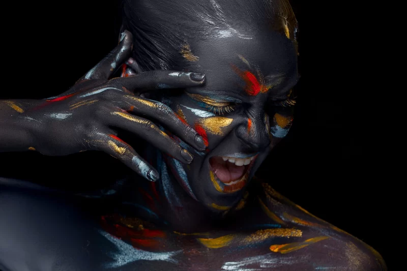 Portrait of a young woman who is posing covered with black paint Free Photo